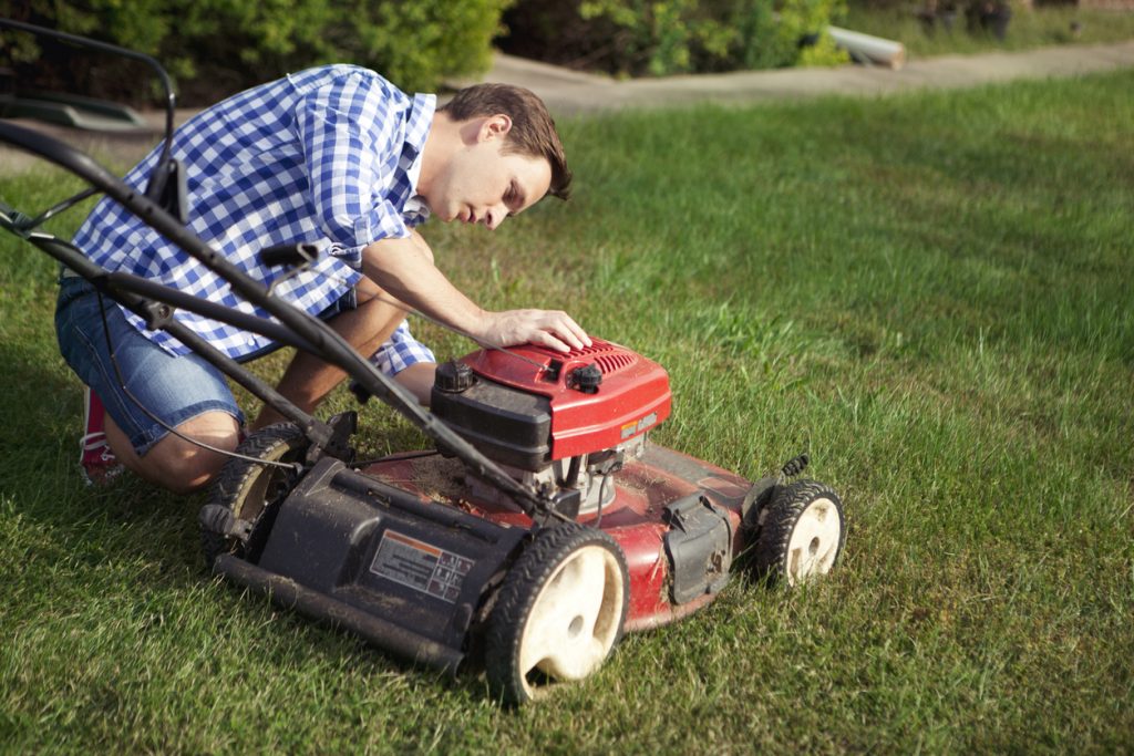 Man provides maintenance for his lawn mower.