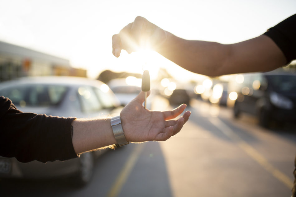 Owner passing keys to salesperson for trade in 