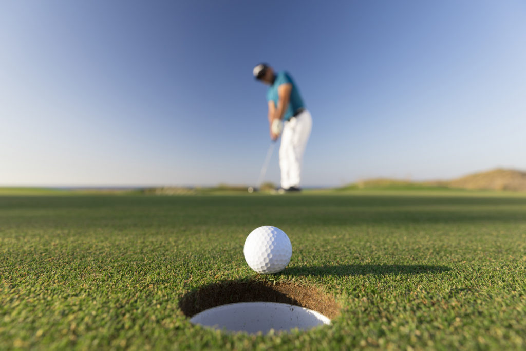 Golf ball entering the hole after successful stroke