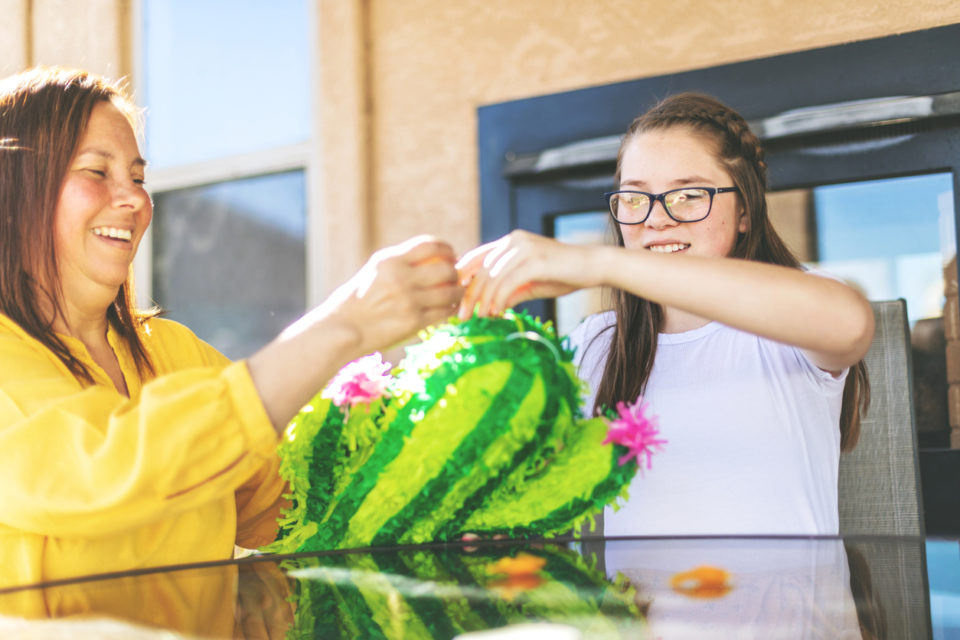 mother and daughter working on piñata 