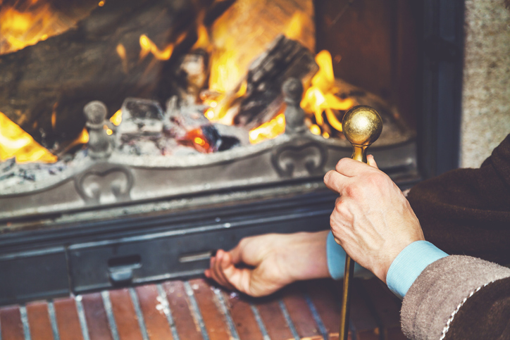 right hand flap open fireplace ash. The fire burn bright wood. The left hand holds the brass poker.